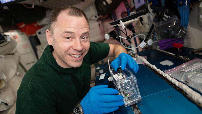 NASA astronaut Nick Hague works on the Genes In Space 6 experiment that is aimed at studying radiation damage to DNA.