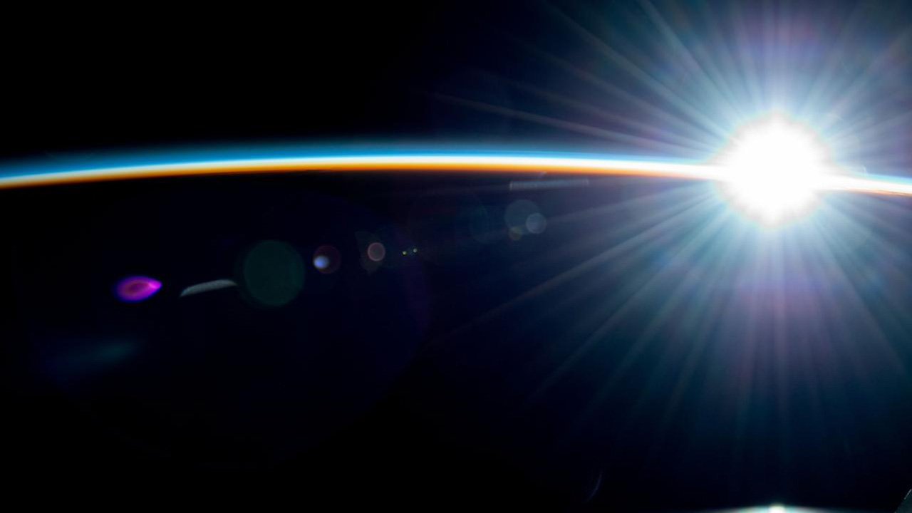 Earth's atmosphere from the ISS as it soars into a radiant orbital sunrise