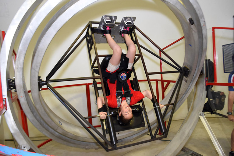 Payton tests her ability to tolerate extreme accelerations on the Multi Axis Trainer at Space Camp.