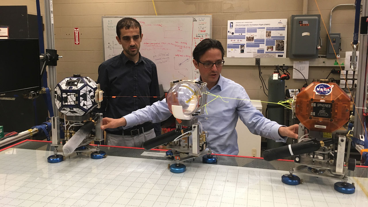 Danilo Roascio of MIT and Philipp Behruzi at MIT Labs conducting a first experimental setup of SPHERES Tether Slosh. 