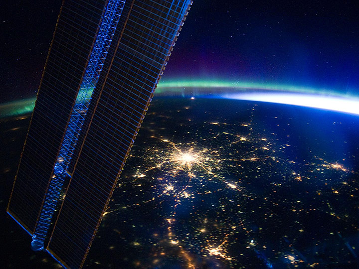 ISS030 E 185321 (28 March 2012) Moscow, Russia appears at the center of this nighttime image photographed by one of the Expedition 30 crew members aboard the International Space Station, flying at an altitude of approximately 240 miles. A solar array panel for the space station is on the left side of the frame. The view is to the north northwest from a nadir of approximately 49.4 degrees north latitude and 42.1 degrees east longitude, about 100 miles west northwest of Volgograd. On the horizon in the background can be seen a small sample of Aurora Borealis, airglow and daybreak.