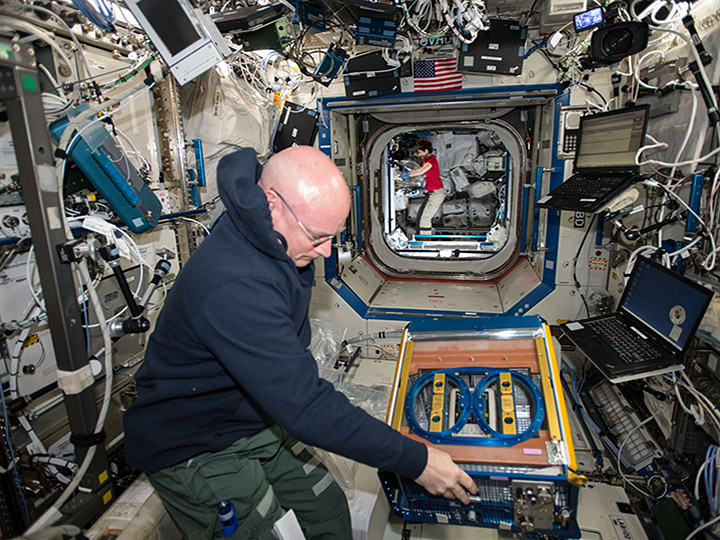 NASA astronaut Scott Kelly handling the Rodent Research Facility onboard the International Space Station.