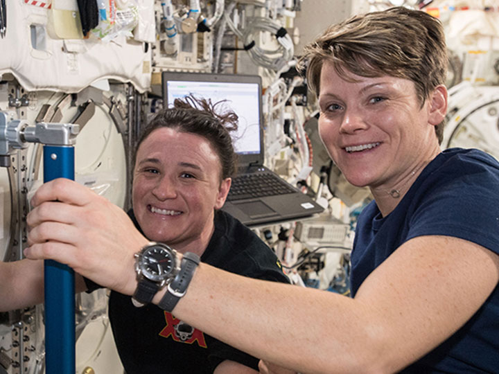 NASA astronauts Serena Aun Chancellor (background) and Anne McClain onboard the International Space Station.