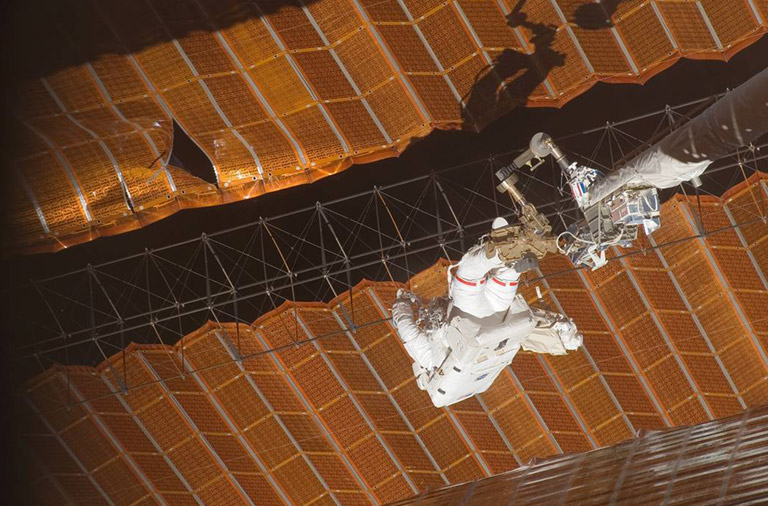 SS016 E 009184 (3 Nov. 2007) While anchored to a foot restraint on the end of the Orbiter Boom Sensor System (OBSS), astronaut Scott Parazynski, STS 120 mission specialist, participates in the missions fourth session of extravehicular activity (EVA) while Space Shuttle Discovery is docked with the International Space Station. During the 7 hour, 19 minute spacewalk, Parazynski cut a snagged wire and installed homemade stabilizers designed to strengthen the damaged solar arrays structure and stability in the vicinity of the damage. Astronaut Doug Wheelock (out of frame), mission specialist, assisted from the truss by keeping an eye on the distance between Parazynski and the array. Once the repair was complete, flight controllers on the ground successfully completed the deployment of the array.