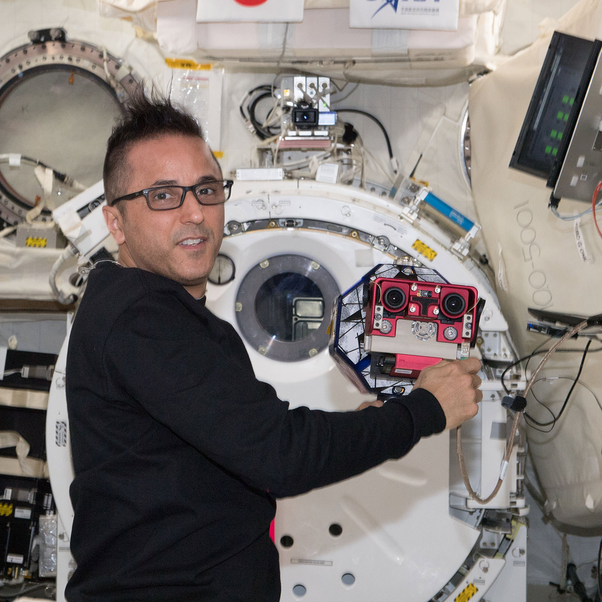 NASA astronaut Joe Acaba works with the SPHERES satellite as part of the SmoothNav investigation.