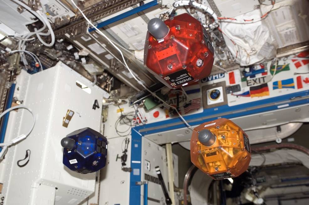 Three in orbit SPHERES satellites fly in formation through the International Space Station.