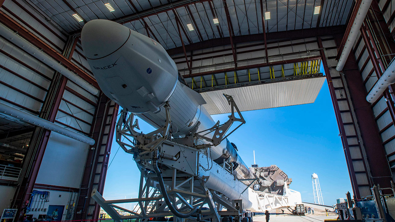 A SpaceX Falcon 9 rocket, topped with the upgraded version of the Cargo Dragon spacecraft, is seen inside the companys hangar at NASAs Kennedy Space Center in Florida on Dec. 2, 2020, prior to being rolled out to the launch pad in preparation for the 21st Commercial Resupply Services (CRS 21) launch.