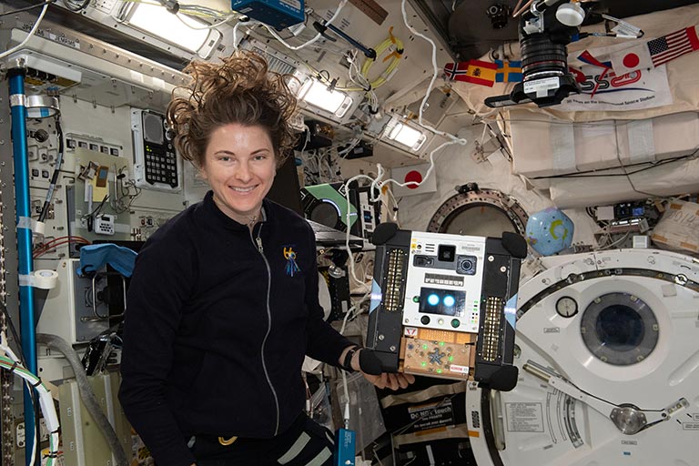 NASA astronaut Kayla Barron sets up an Astrobee for the SoundSee experiment.