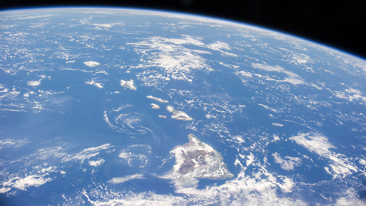Peeking through the scattered clouds over the North Pacific Ocean on September 19, 2014 are the eight major islands that comprise the archipelago of the Hawaiian Islands.