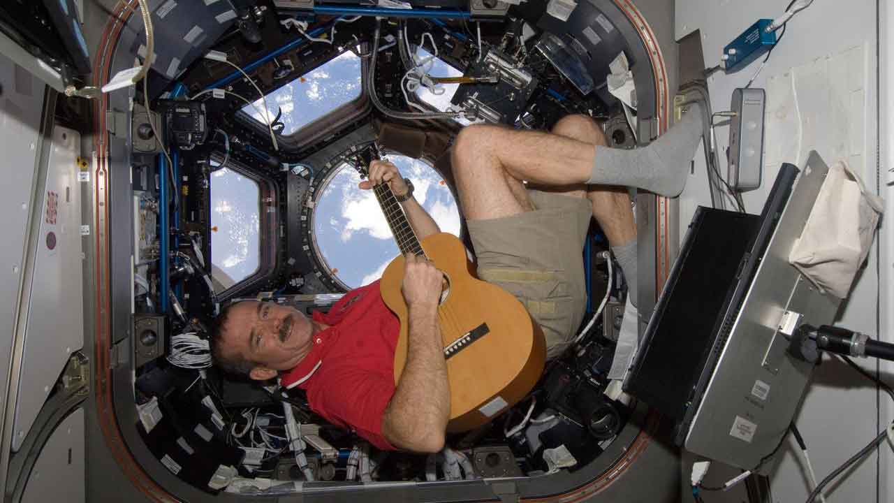 chris-hadfield-guitar-cupola Canadian Space Agency astronaut Chris Hadfield, Expedition 34 Flight Engineer, playing guitar in the Cupola Module on the International Space Station