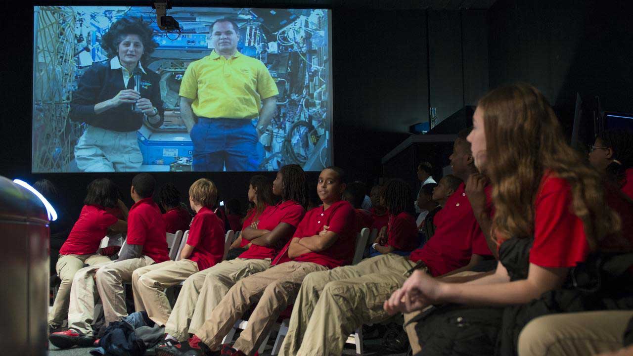 stem-research-students-downlink International Space Station Expedition 33 Commander Sunita Williams (on screen) answers questions from students during a downlink event held in honor of International Education Week at the Smithsonian National Air and Space Museum