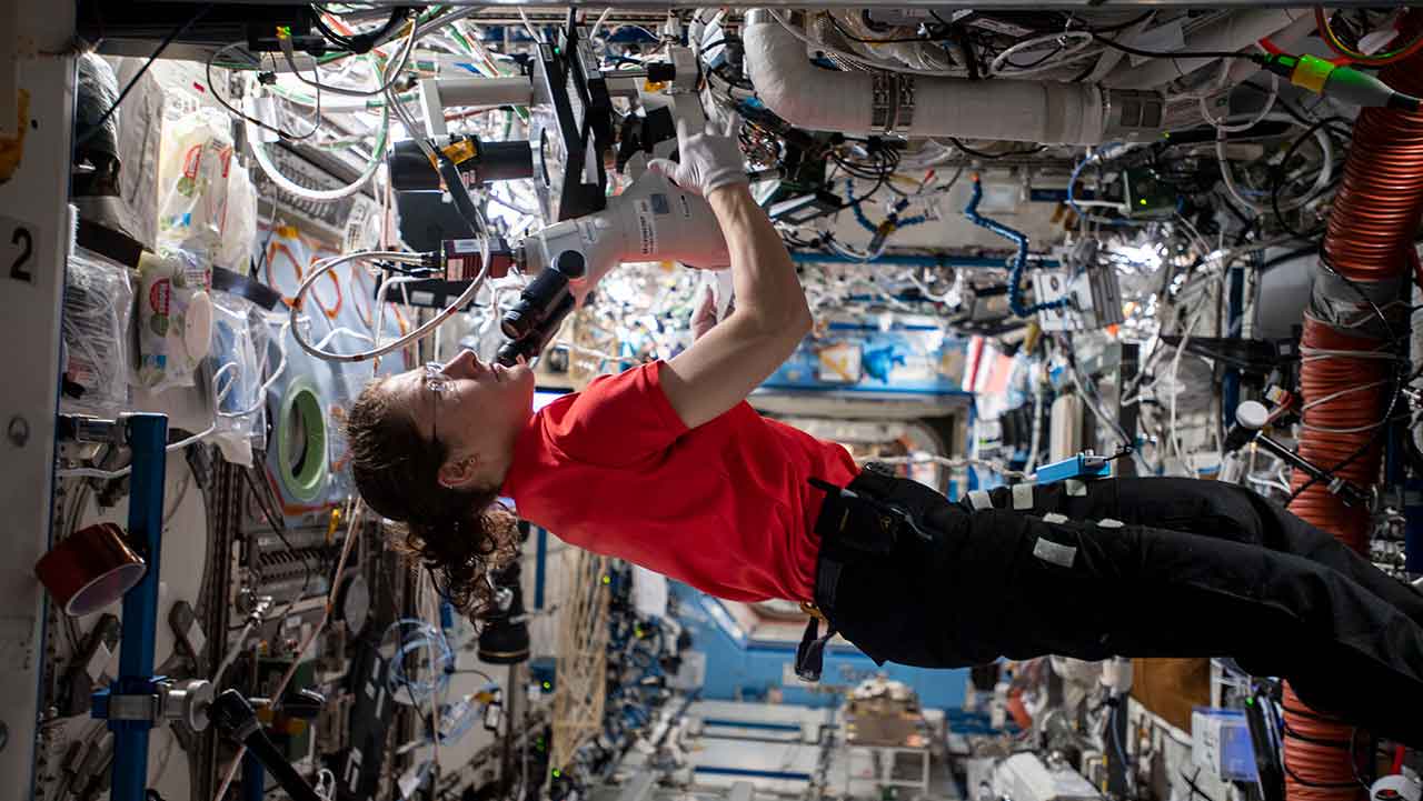 NASA astronaut Christina Koch working on MicroQuin's protein crystallization investigation on the ISS.
